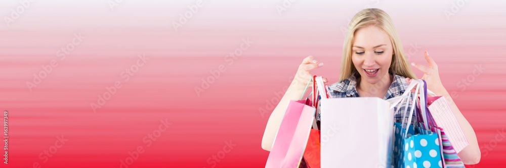 Shopper looking into bags against blurry red background