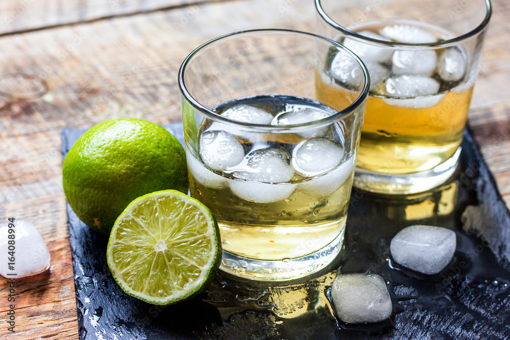 glass of whiskey on wooden background