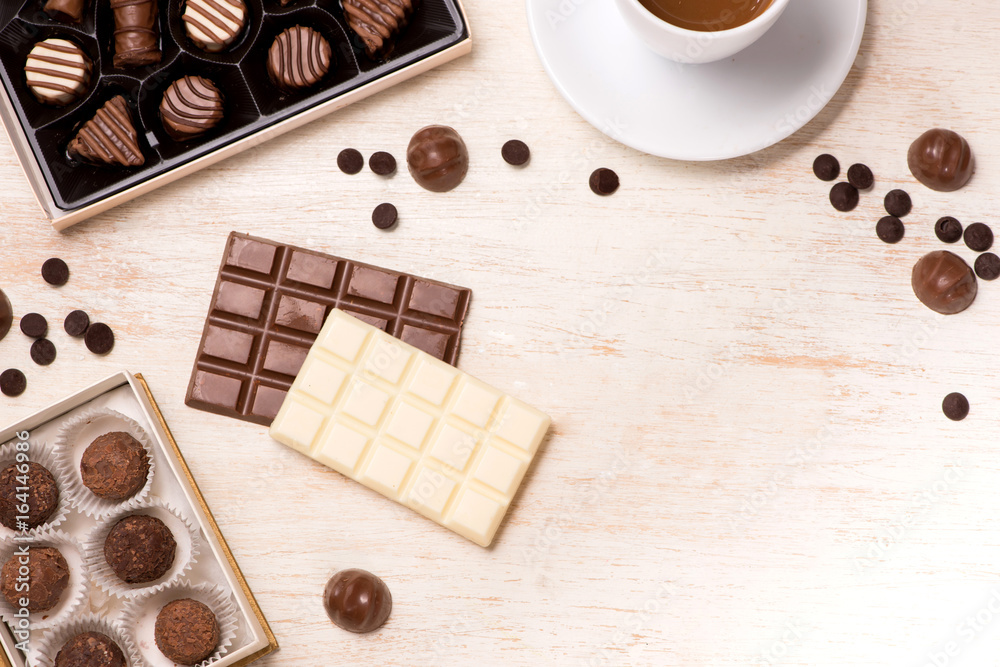 Glass of chocolate milk and variety chocolates  on table