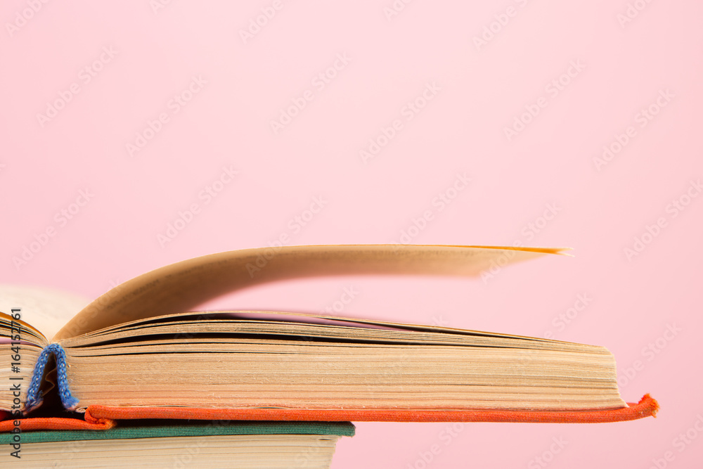 education and wisdom concept - open book on wooden table, color background