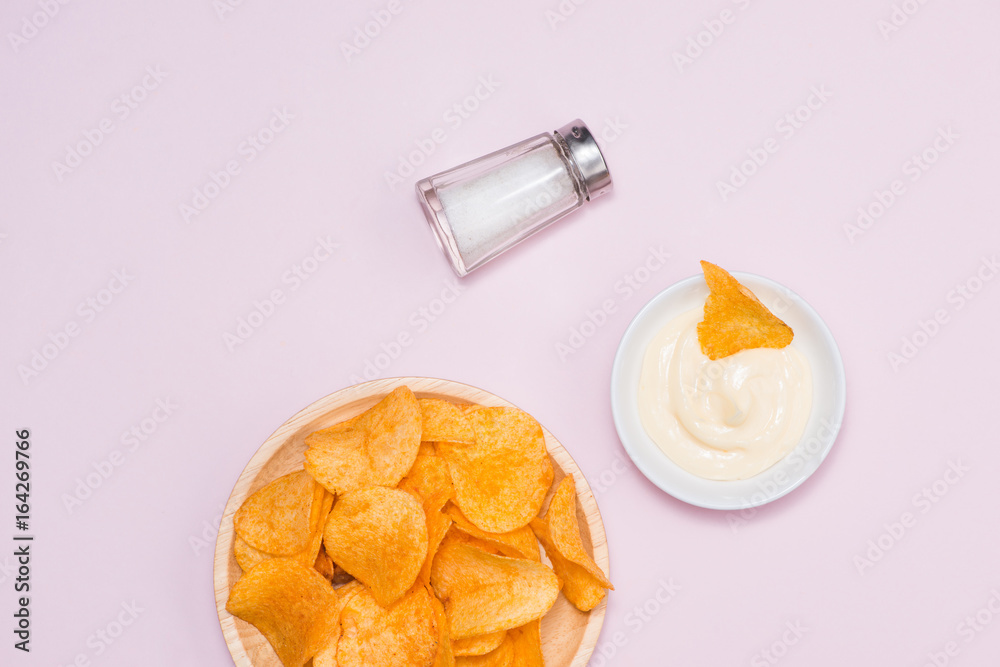 Concept of unhealthy food. Cheese and onion potato chips on pink background.