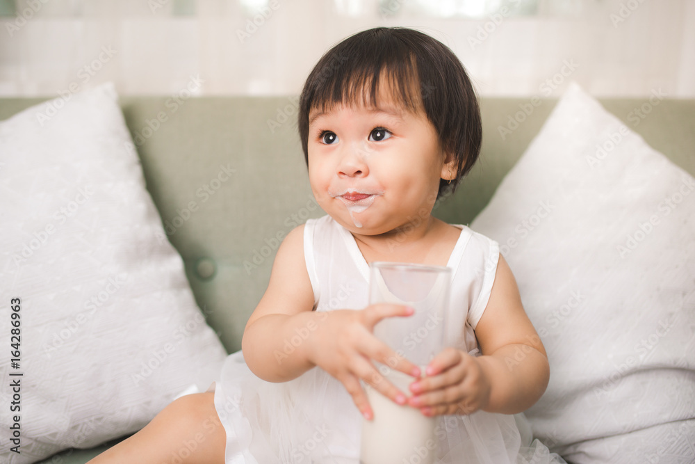 可爱的女婴在家留着牛奶胡子喝牛奶