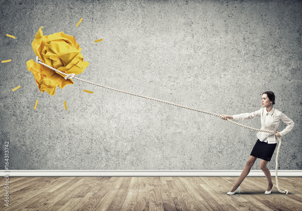 Businesswoman pulling paper ball with rope and making it raise up