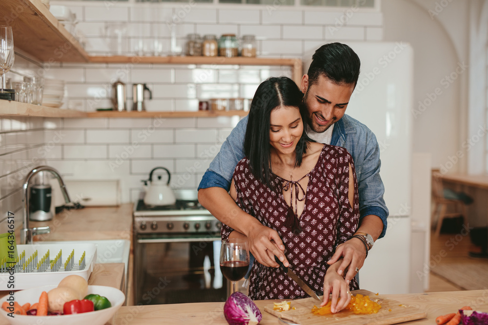 Romantic couple cooking in kitchen at home