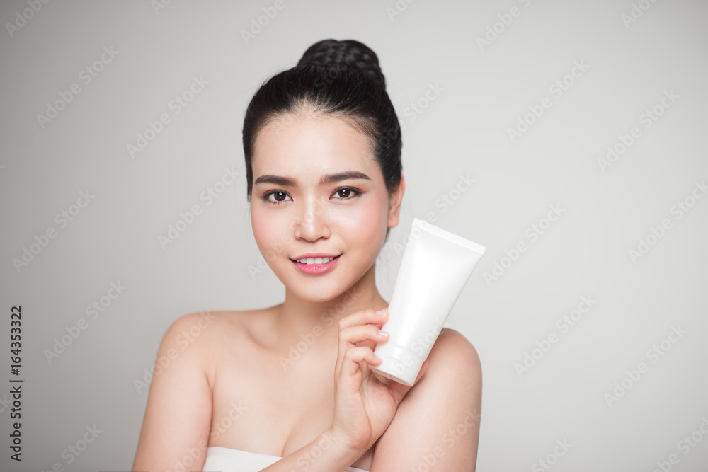 Beauty concept. Asian pretty woman with perfect skin holding cosmetic bottle