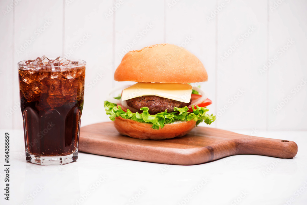 Homemade BBQ burger with coke on wooden background.