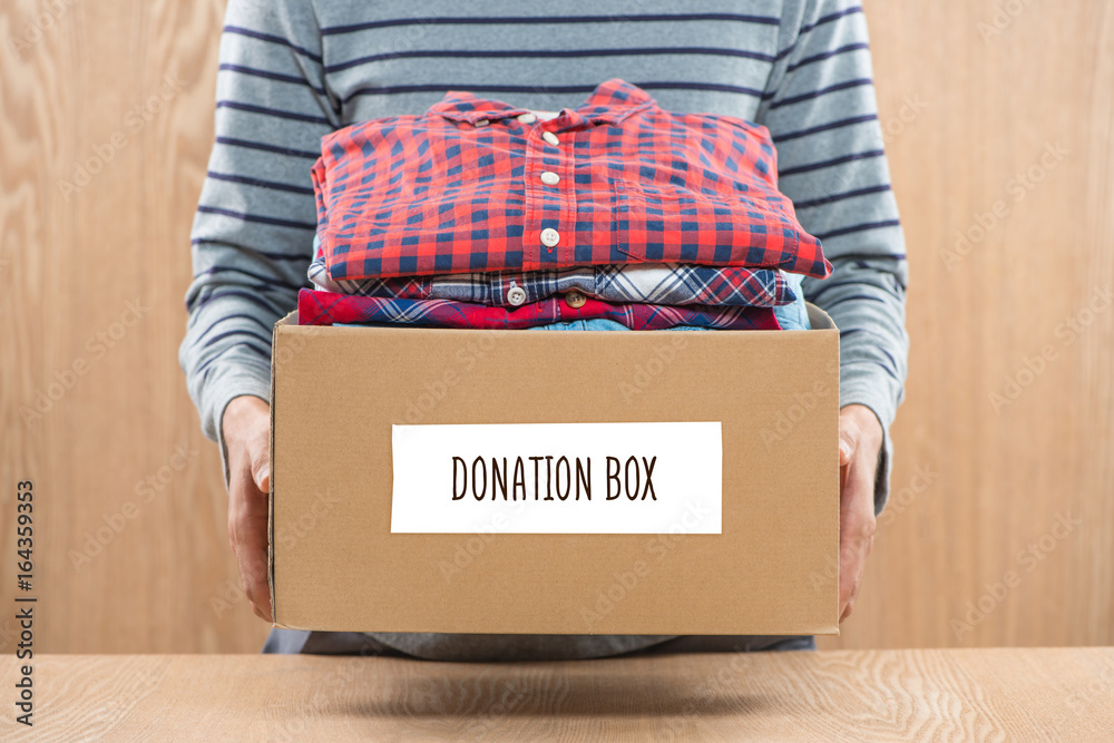 Donation box for poor with clothing in male hands