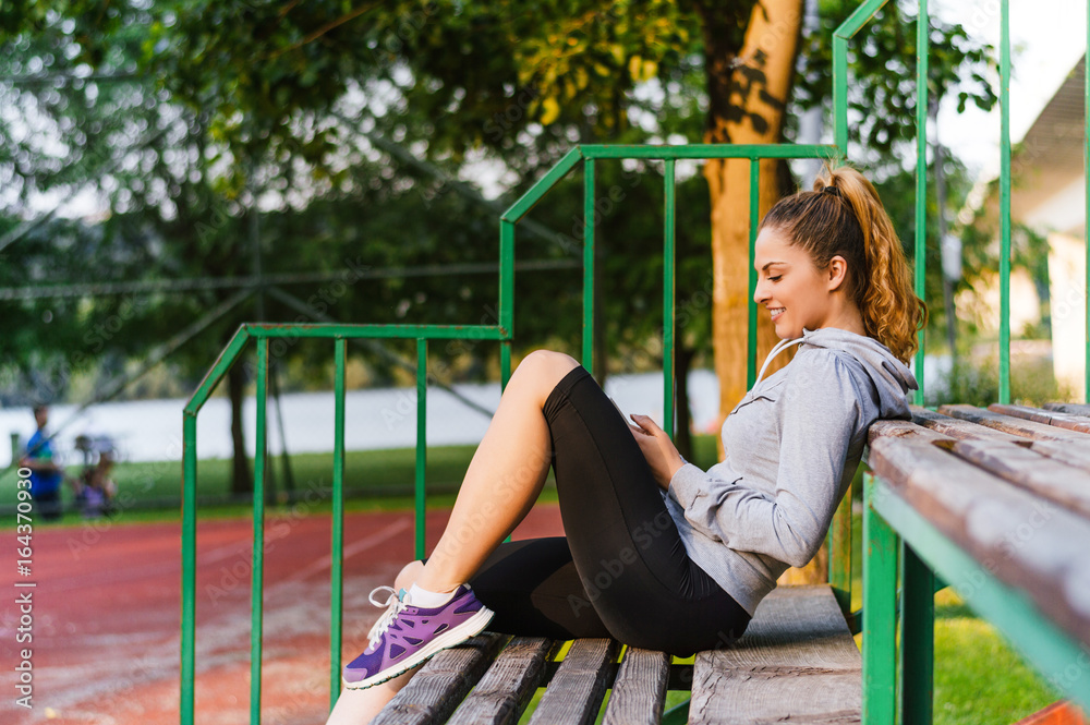 Young athletic woman sitting on a bench