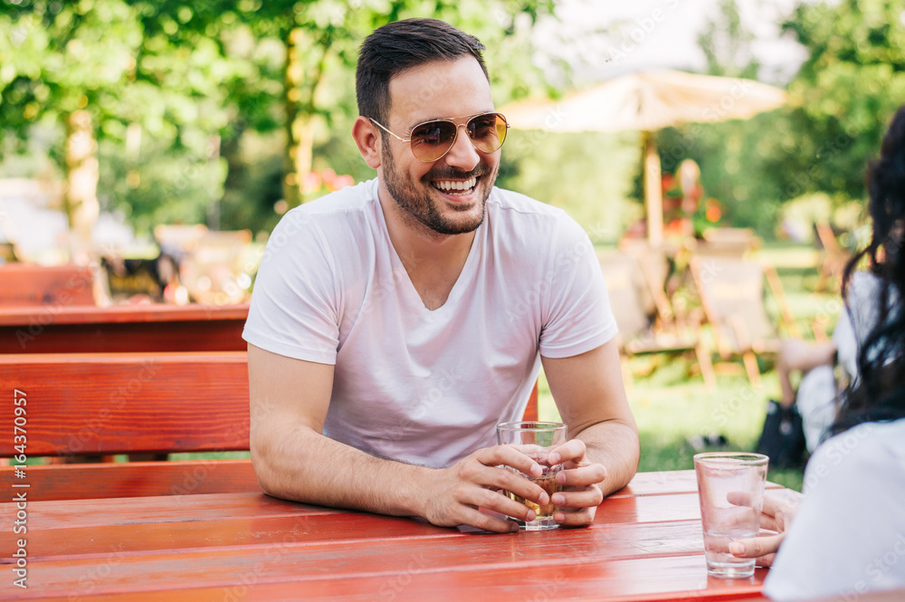 Two people are sitting in a cafe, drinking and enjoying a conversation.