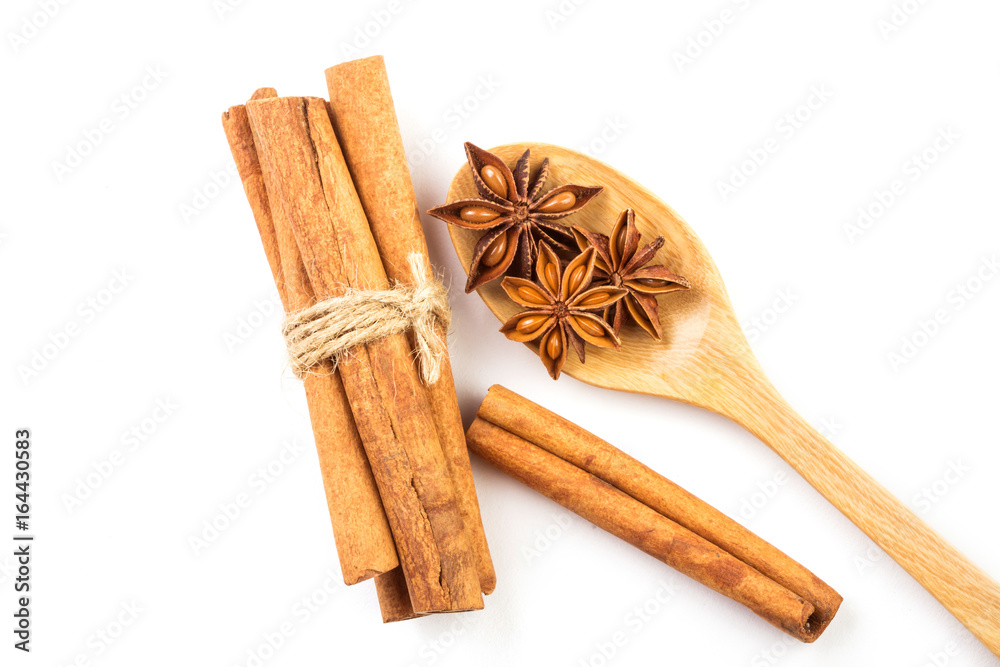 Close up brown cinnamon stick with star anise spice in wooden spoon isolated on white background