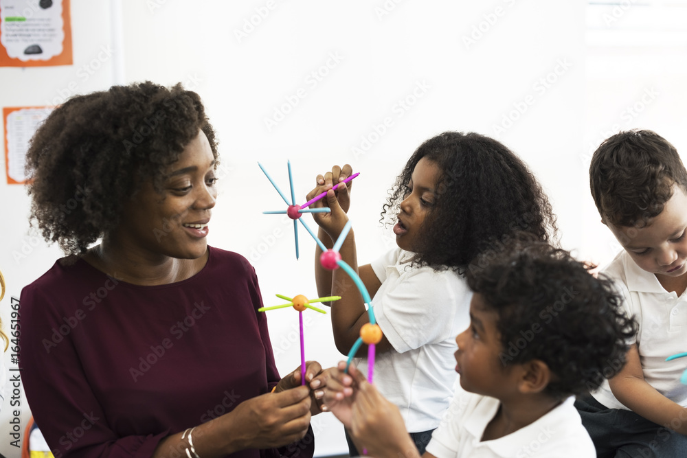 Diverse kindergarten students holding learning structures from toys