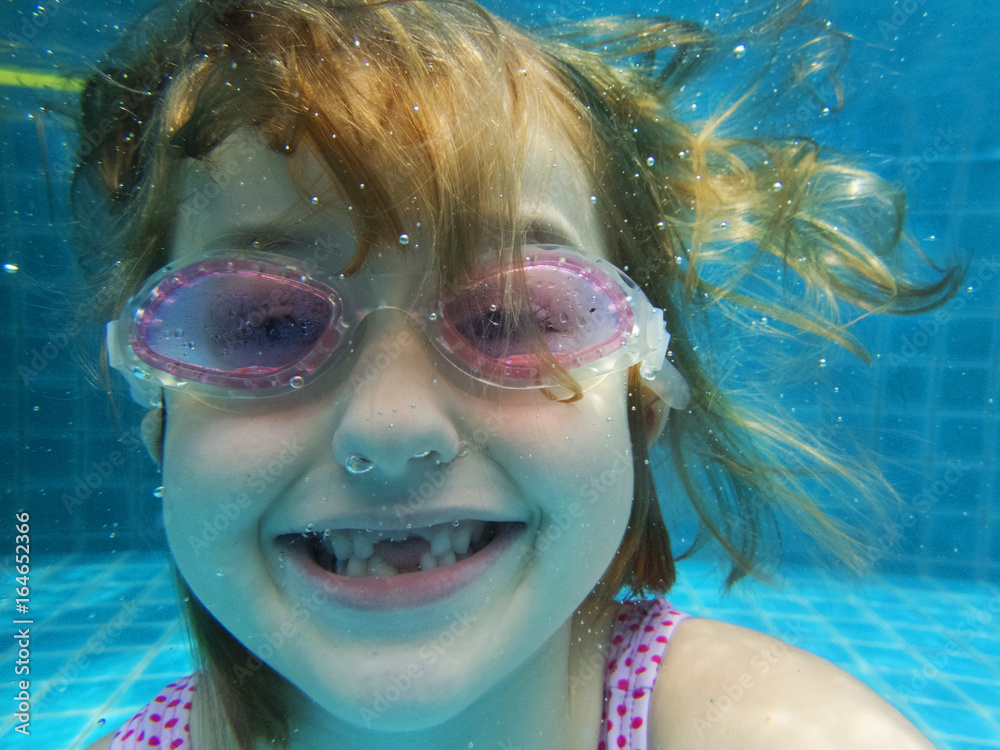 Closeup of caucasian girl underwater in the pool