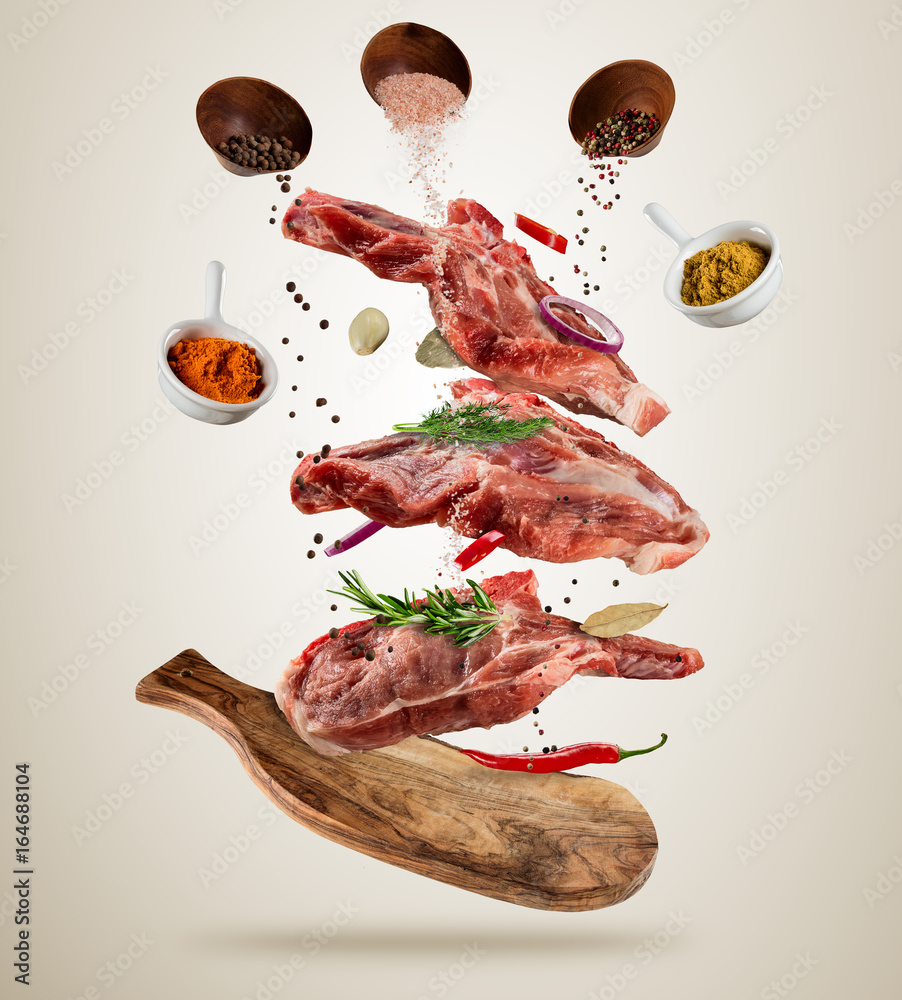 Flying raw pork steaks with ingredients, food preparation concept