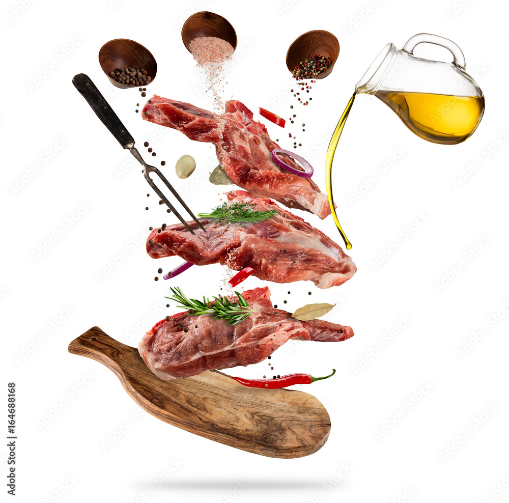 Flying raw pork steaks with ingredients, food preparation concept