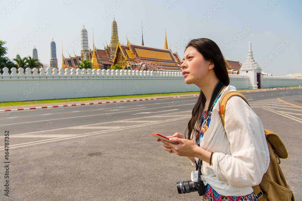 智能手机上的女人走在皇宫上