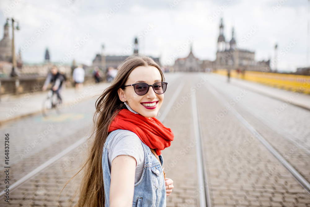 Lifestyle portrait of a business woman walking the bridge in the old town of Dresden, Germany