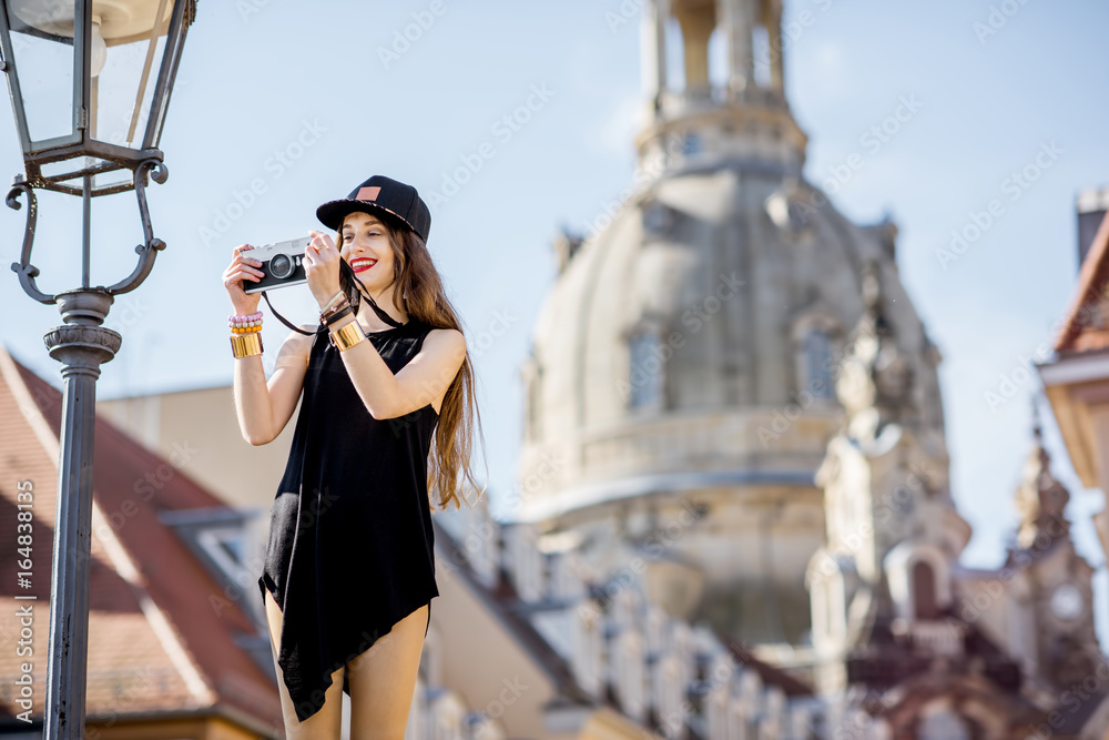 Young woman tourist standing with photo camera on the famous Bruhl terrace with great view on the ol