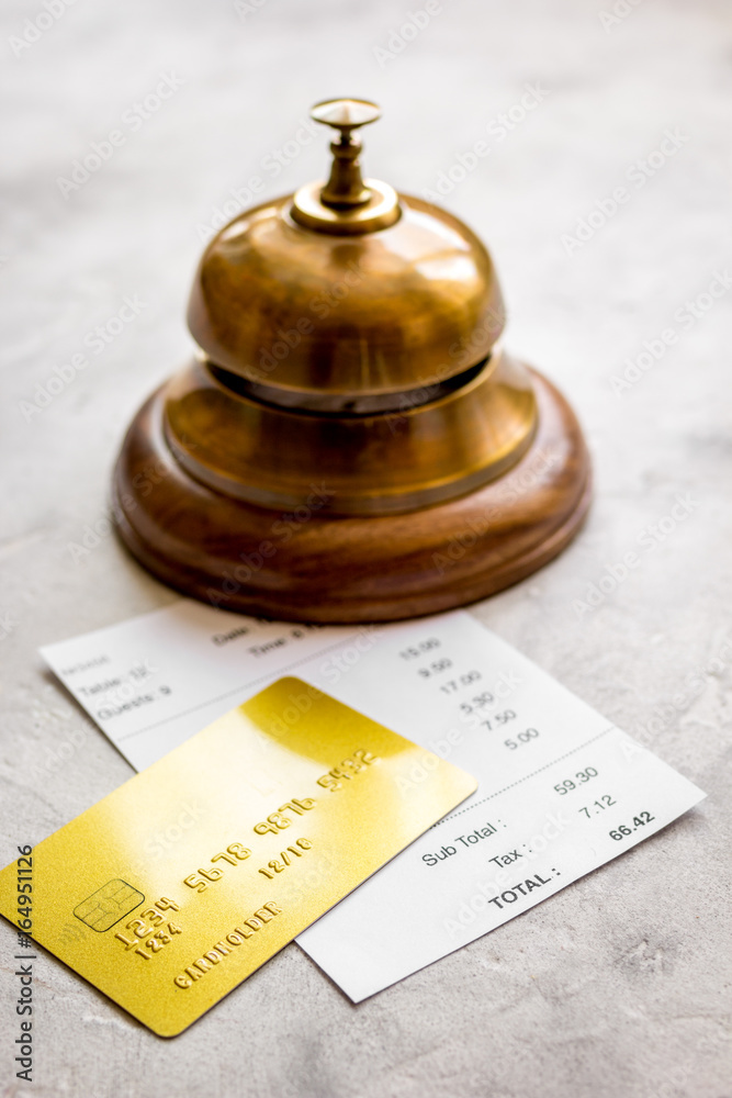 credit card for paying, waiter ring and check on cafe stone desk background