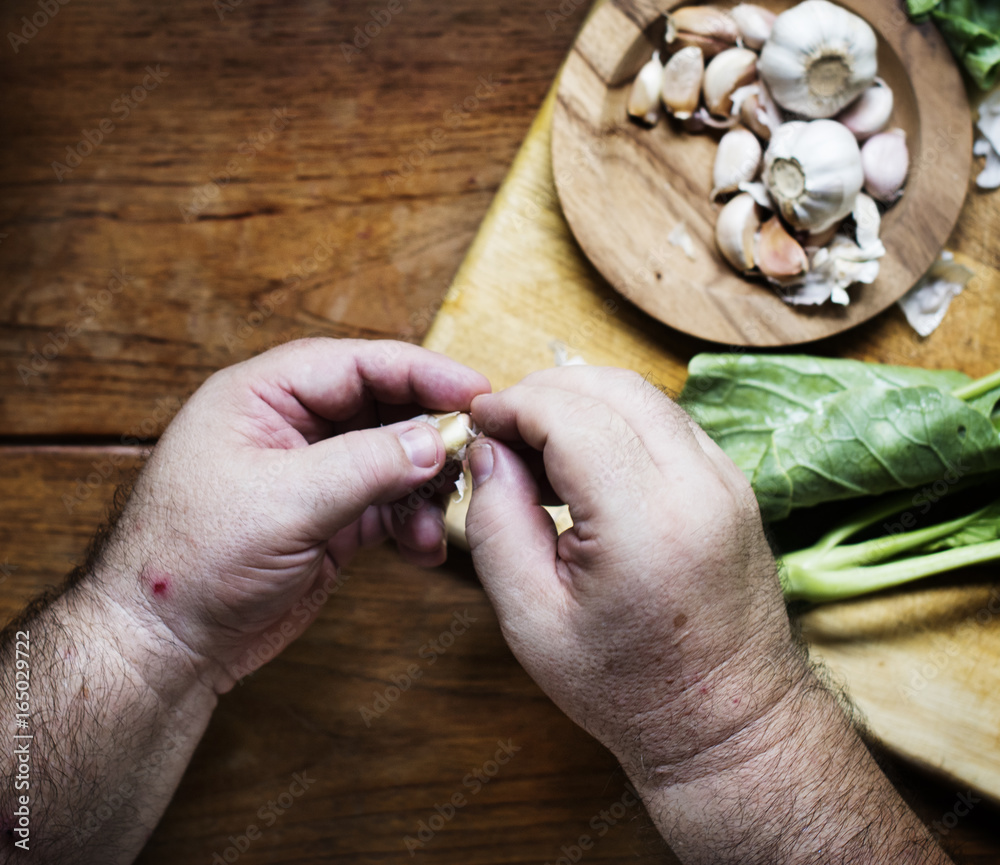 Aerial view of hands peeling garlic cloves