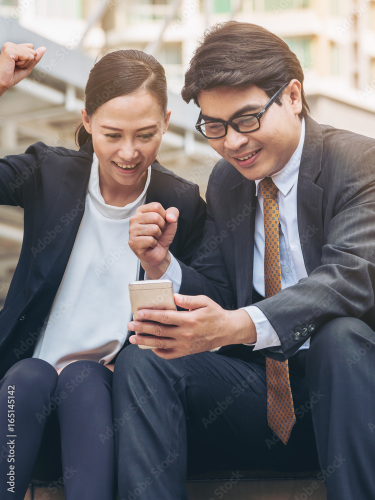 Happy business man and woman looking at phone