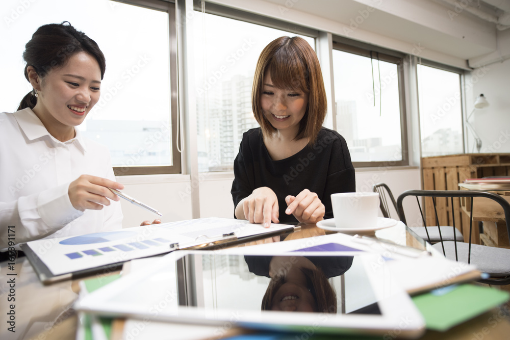 两位女士正在一家咖啡馆工作时会面