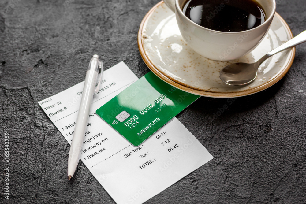 restaurant bill paying by credit card for coffee on dark table background