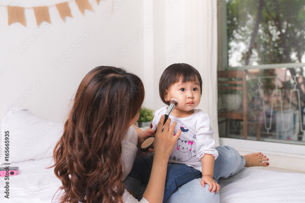 Lovely princess is applying the make up on her skin with special brush as she wants to look like her