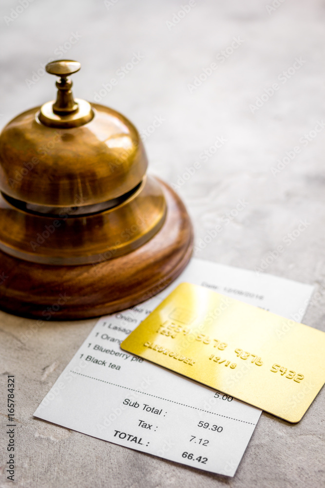 restaurant bill, card and waiter ring on stone table background