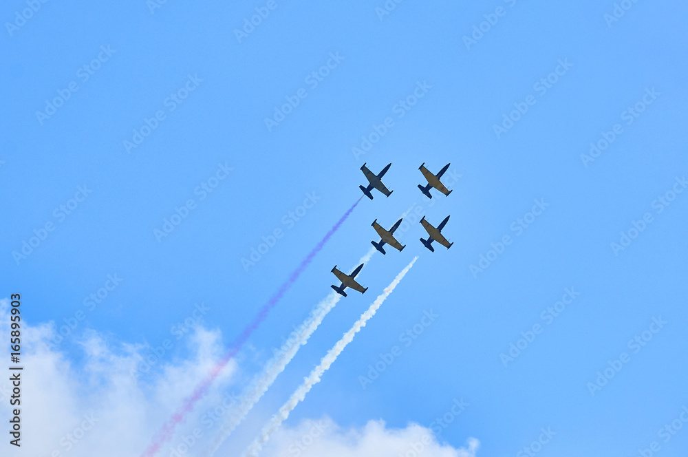 Sport planes aerobatic team vapour trails in blue sky. Plane white vapour trails tracks background. 