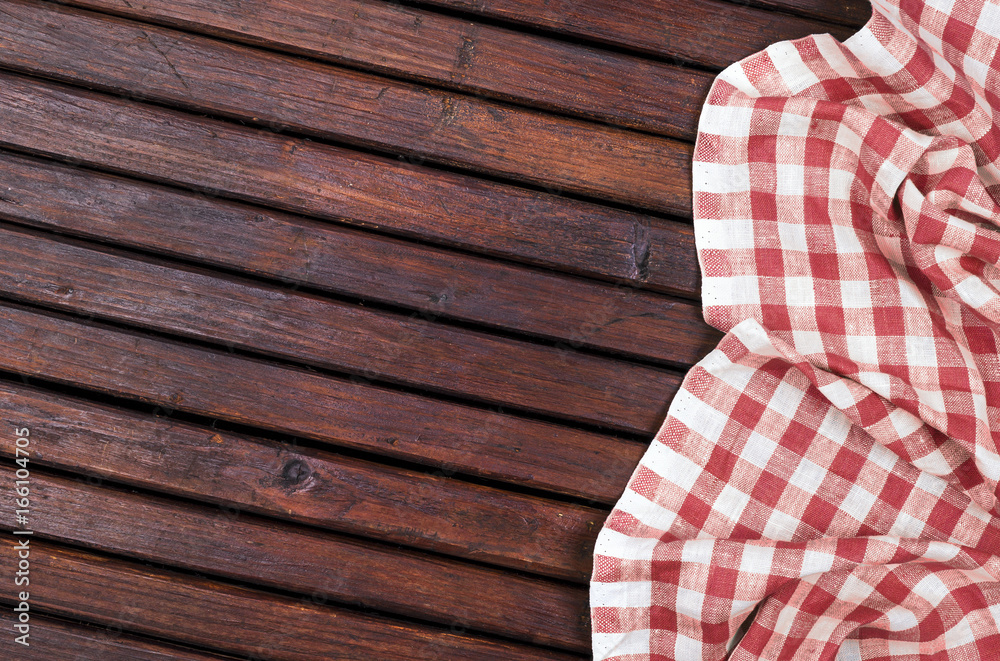 Red checkered tablecloth on dark wooden table with, top view with copy space