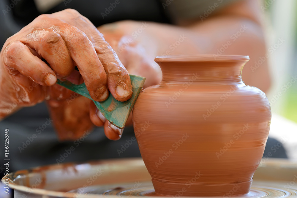 Potter making ceramic pot on the pottery wheel