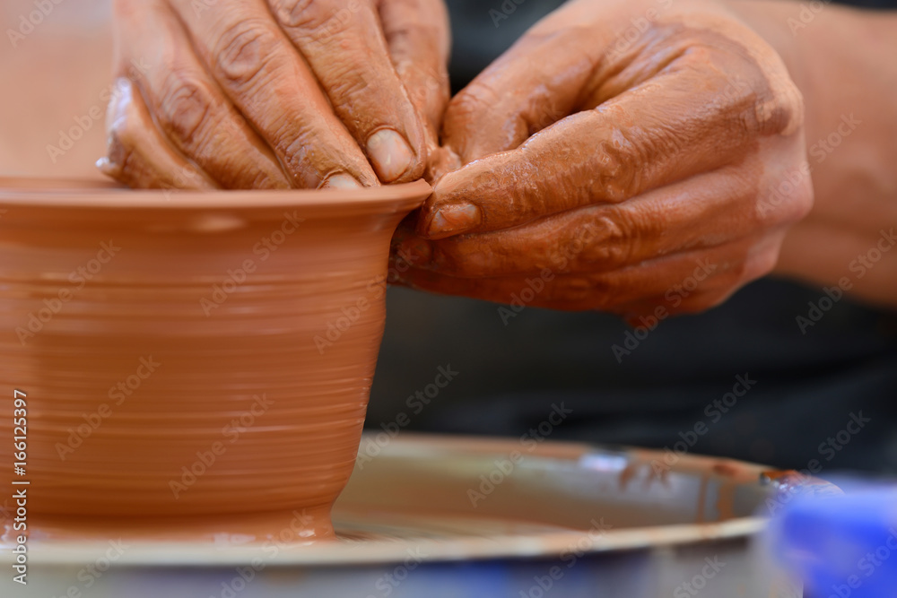 Potter making ceramic pot on the pottery wheel