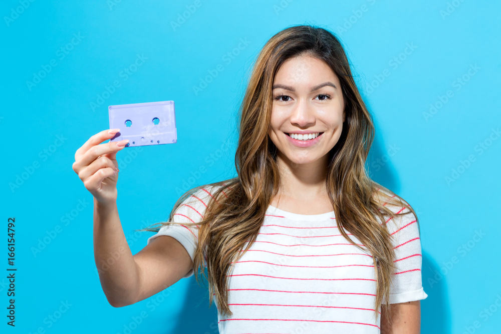 Happy woman with a retro cassette tape