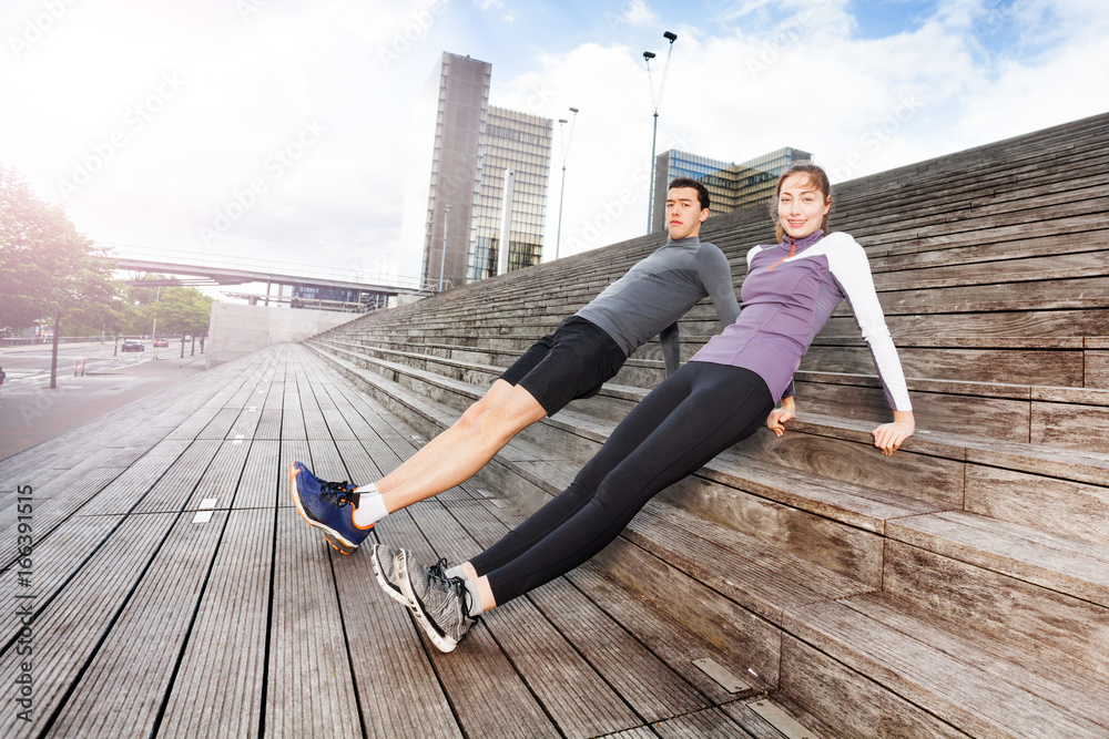 Sporty young couple exercising together outdoors