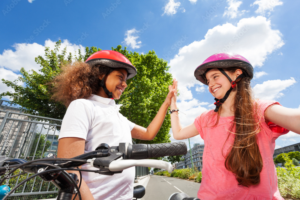 Happy bike riders giving high five after racing