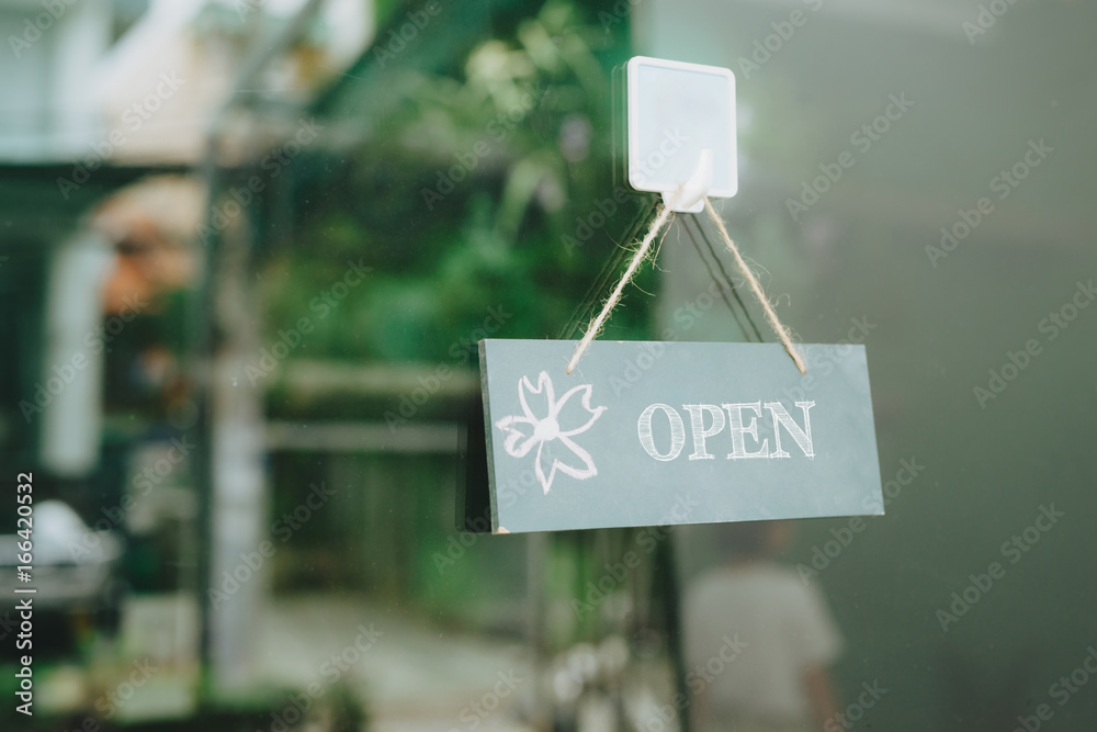 Open sign on glass door at flower shop