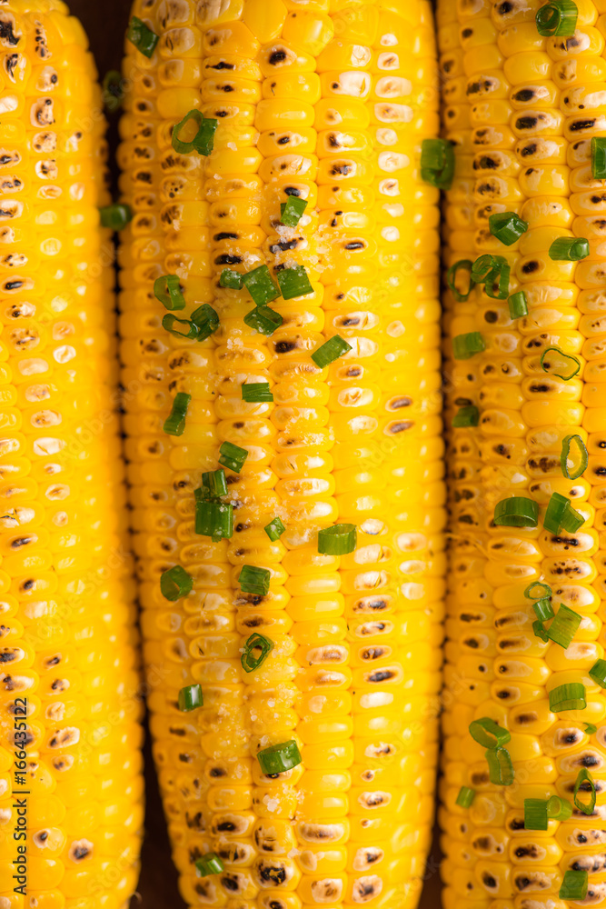 Closeup of tasty sweet grilled corn with onion sauce