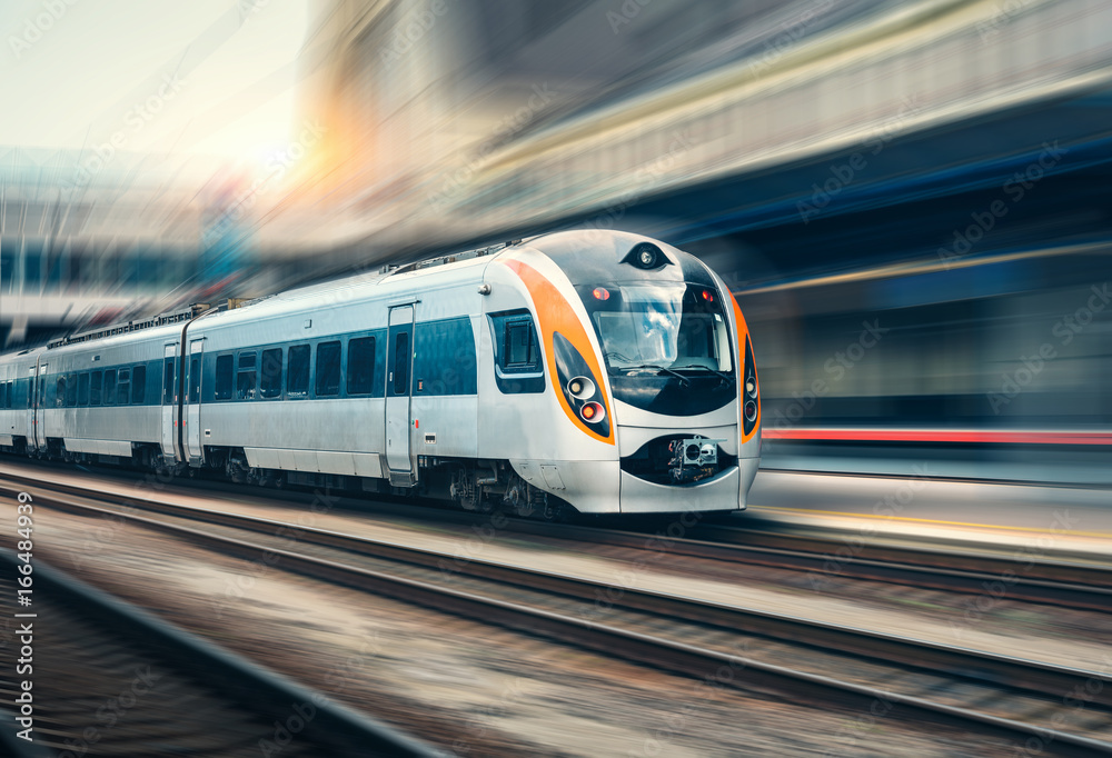 High speed train in motion at the railway station at sunset