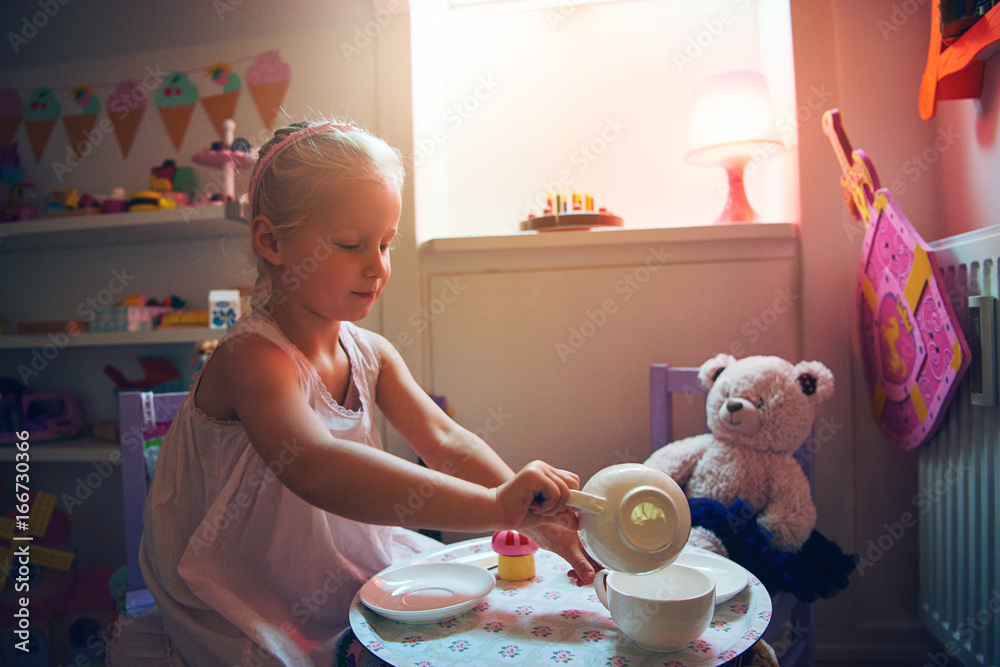 Girl serving tea for her toy bear