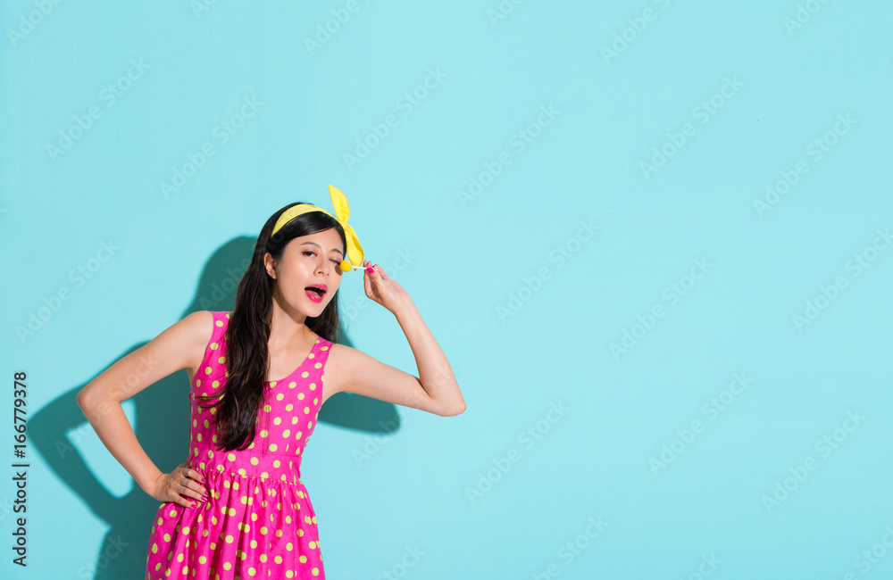 pretty woman wearing cute dress in blue wall