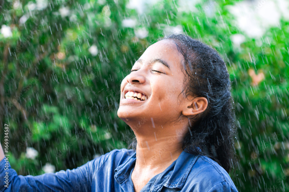 一个微笑的女孩，与雨水一起快乐