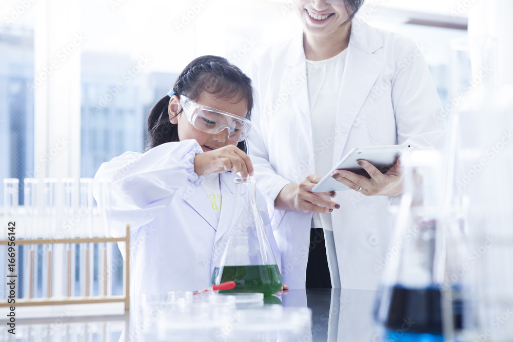 The girl is doing an experiment with the teacher