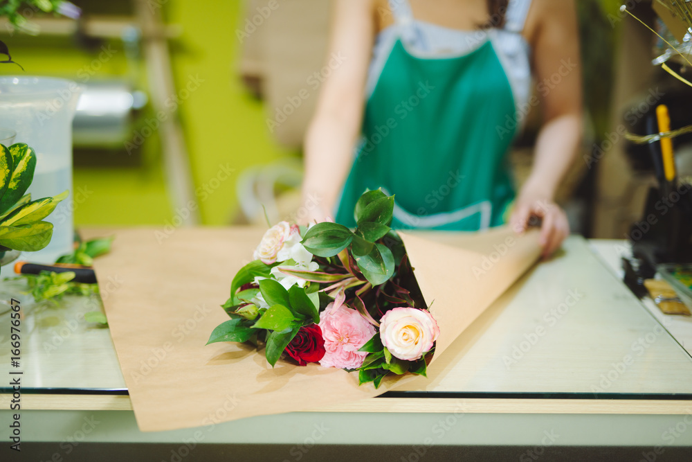 Female florist making beautiful bouquet at flower shop