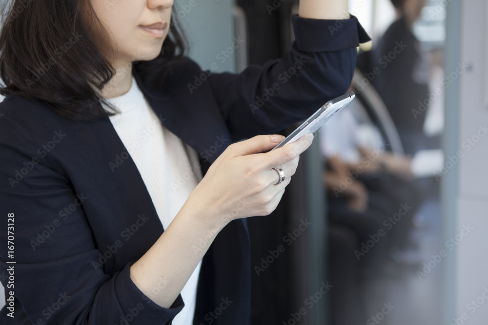 一名女子被抓到在火车内挂着皮革，正在看智能手机