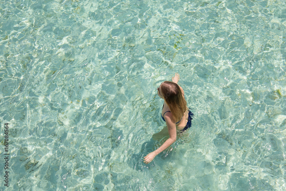 Young girl swimming in a turquoise water.