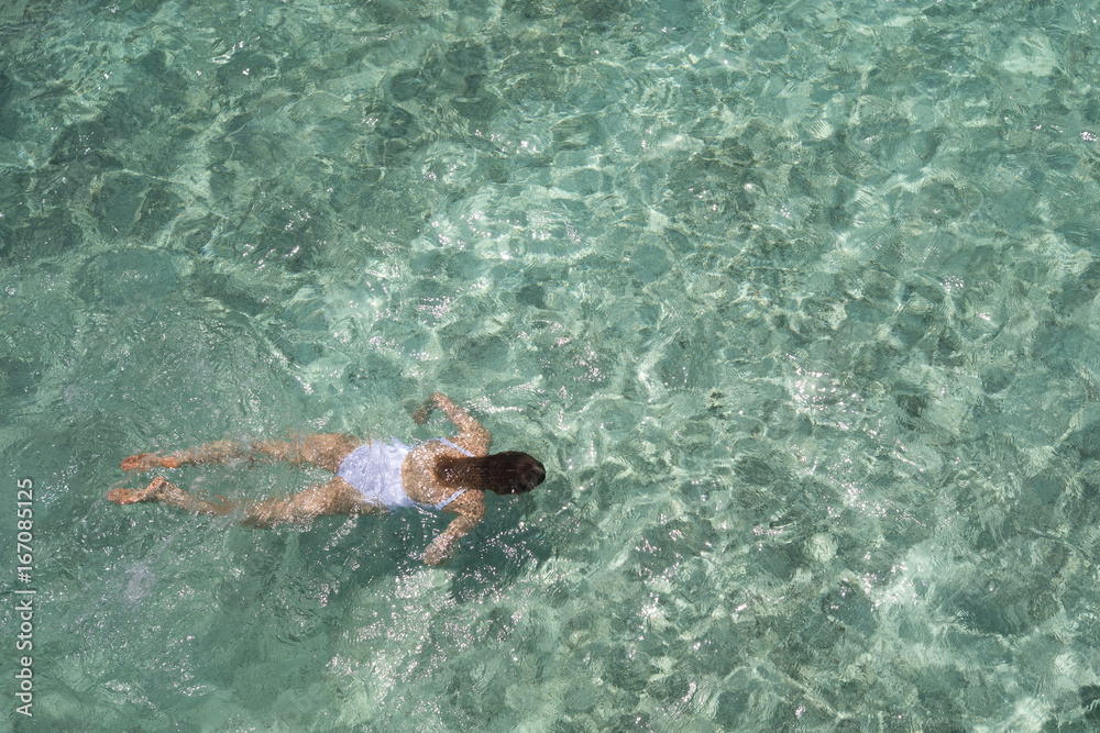 Young girl swimming in a turquoise water.