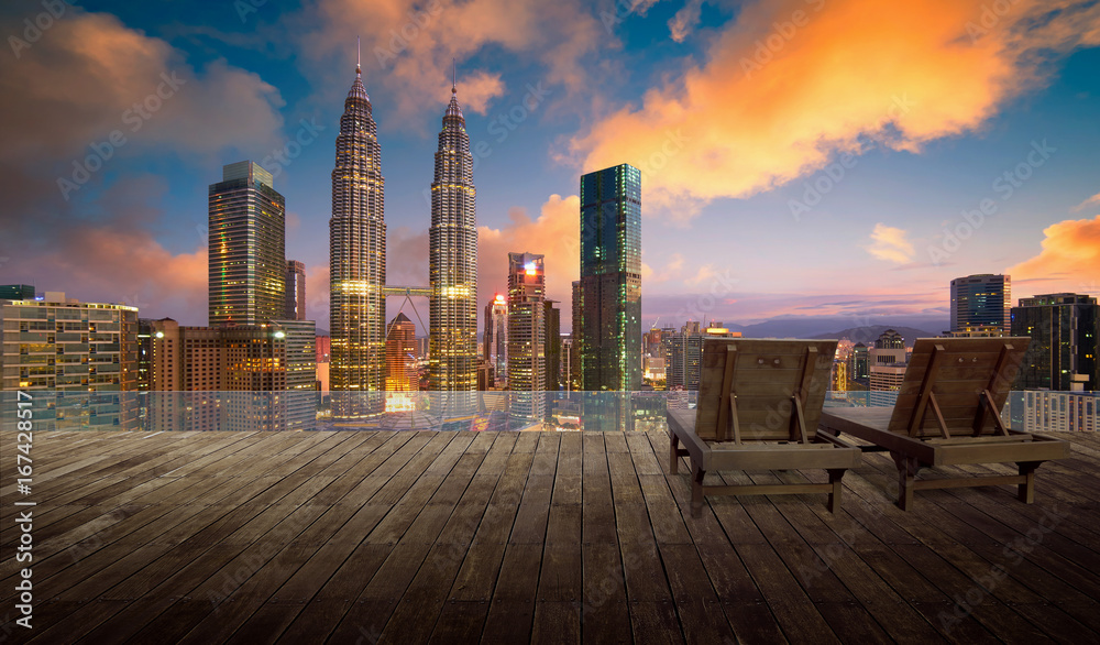 Wooden balcony terrace with wooden relax chair , kuala lumpur city skyline background , night scene 