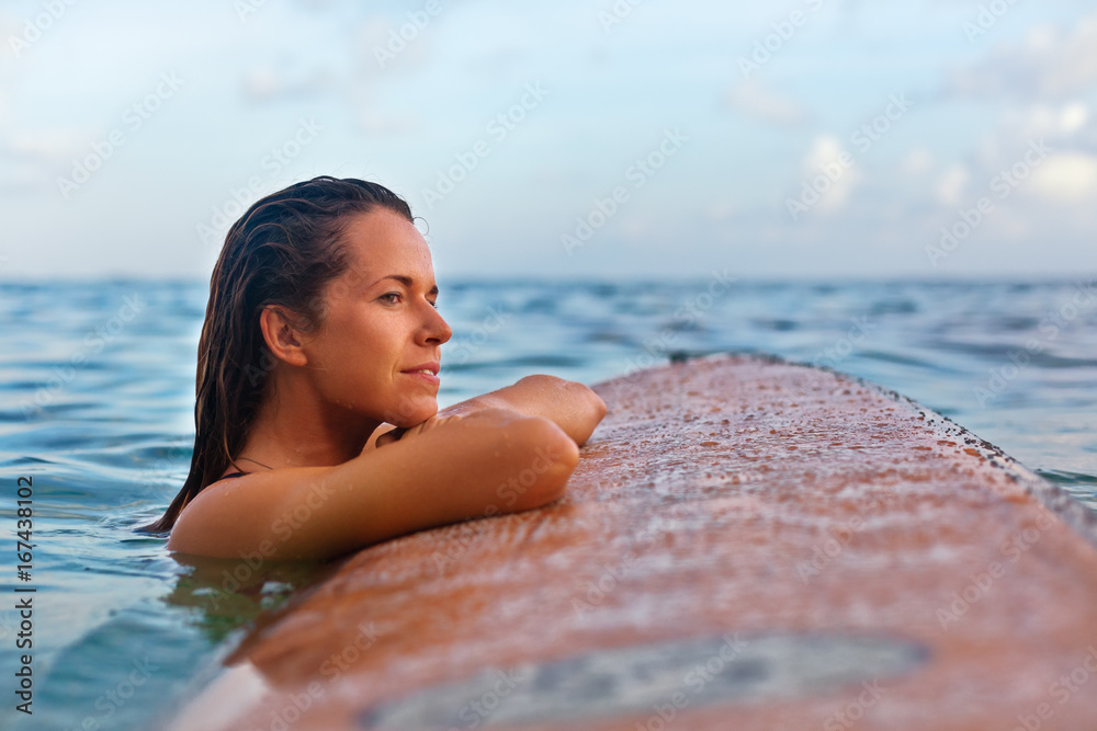 漂浮在海上冲浪板上的女人