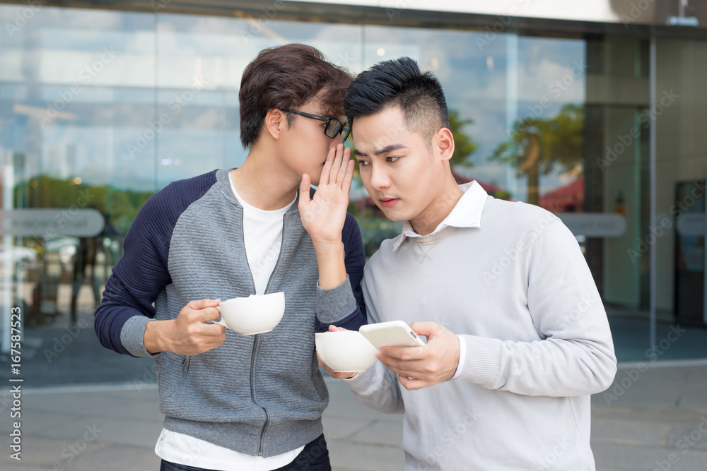 一个人对着男人的耳朵窃窃私语，告诉他一些秘密的特写照片