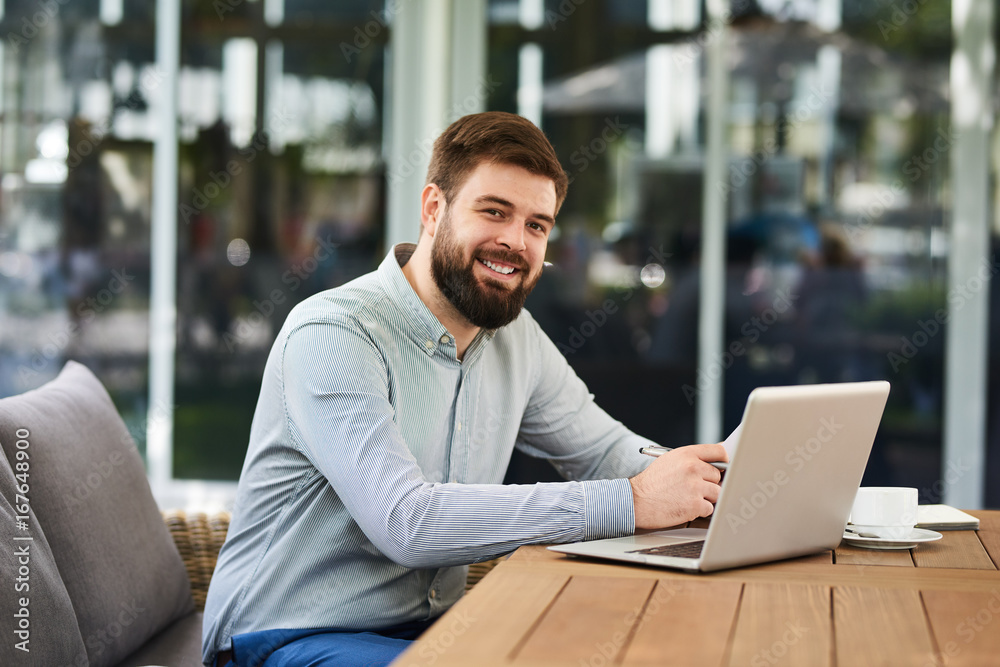 Smiling Bearded Man Working in Office